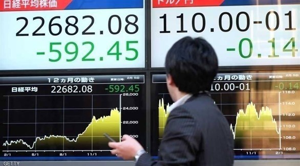 ياباني يقف أمام لوحة إعلانات لأسهم البورصة (أرشيف)