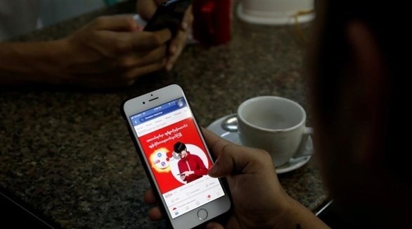 مستخدم يطالع حسابه على فيس بوك على هاتف ذكي في يانجون عاصمة ميانمار يوم 8 أغسطس آب 2018 (رويترز)