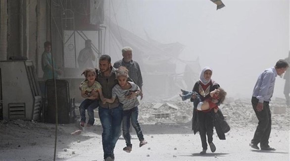 مدنيون يهربون مع أطفالهم بعد غارات على منطقة سكنية في إدلب (أرشيف)