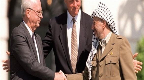 المصافحة التاريخية بين الزعيم الفلسطيني  ياسر عرفات ورئيس الوزراء الإسرائيلي إسحق رابين وبينهما الرئيس الأمريكي بيل كلينتون.(أرشيف)