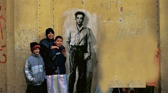 أطفال يقفون بجانب جدارية للناشط موريس أودان (أرشيف)