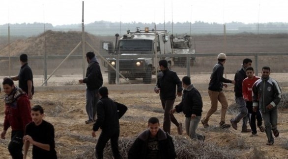 فلسطينيون يتراجعون من قرب السياج الحدودي في غزة مع وصول دورية إسرائيلية.(أرشيف)