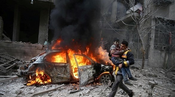مسعف يحمل ولداً بعيداً من سيارة مشتعلة في سوريا.(أرشيف)