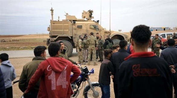 سوريون ينظرون إلى دورية أمريكية في الحسكة (أرشيف)