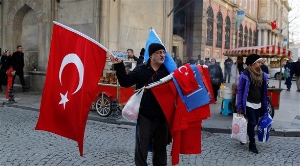 بائع يبيع أعلاماً تركية في أحد الأسواق (رويترز)