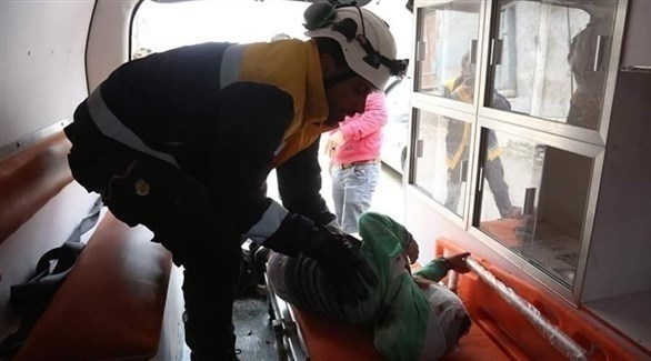  سوري يحاول إسعاف طفل مُصاب في إدلب (تويتر)