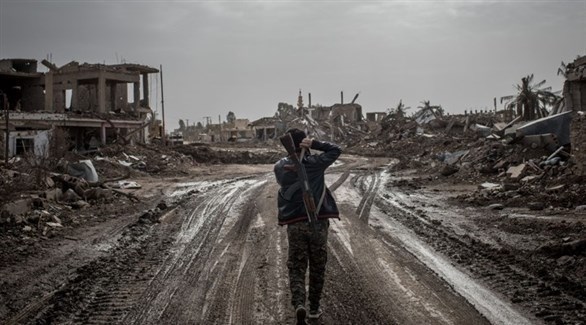 مقاتل من قوات سوريا الديمقراطية في أحد شوارع السوسة المدمرة (أرشيف)