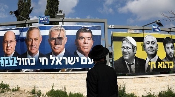 يهودي متدين أمام لافتات انتخابية إسرائيلية (أرشيف)