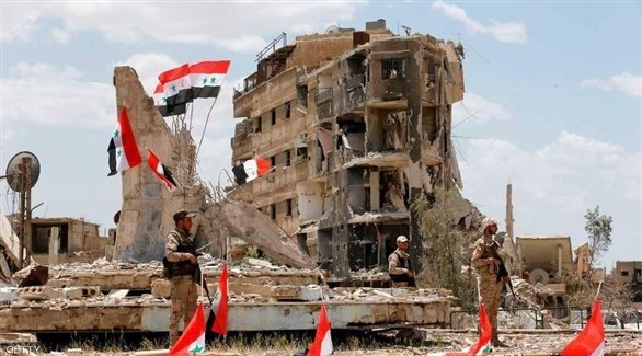 أعلام على مبانٍ مدمرة في سوريا (أرشيف)