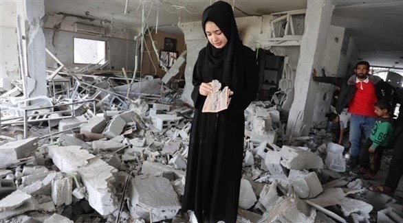 فلسطينية تتفقد ما بقي من منزلها الذي دمر ته غارة إسرائيلية على غزة (أرشيف)