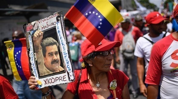 متظاهرة تحمل صورة مادورو في كراكاس (أ ف ب)