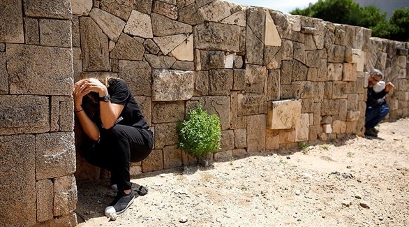 إسرائيليان يحاولان الاحتماء مع دوي صفارات الإنذار.(أرشيف)