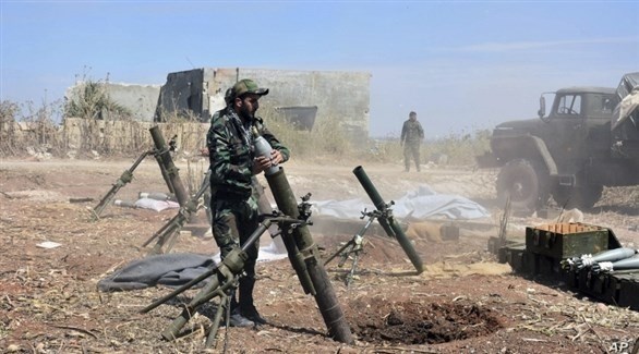 جنود من الجيش السوري يستعدون لإطلاق صاروخ على موقع لقوات المعارضة.(أرشيف)