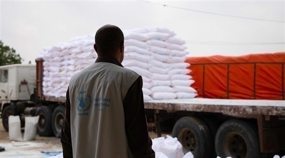 موظف في برنامج الأغذية العالمي ينظر لشاحنة محملة بالمساعدات (أرشيف)