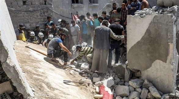 مسعفون من الخوذ البيضاء يحاولون إخراج جثث مدنيين قتلوا في قصف على شمال سوريا (أ ف ب)