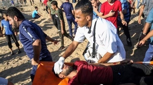 فلسطينيون ينقلون مصاباً في احتجاجات مسيرة العودة على حدود غزة مع إسرائيل (تويتر)