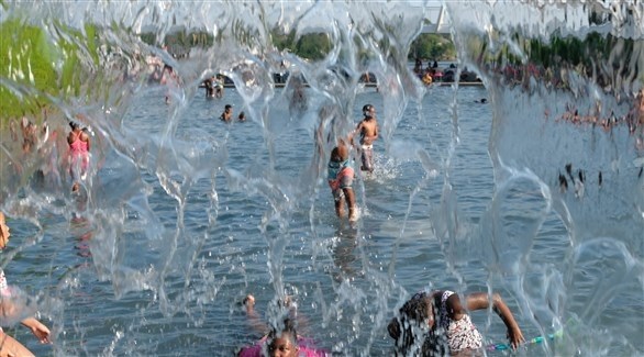 أطفال يلهون داخل بركة ماء في واشنطن (اي بي ايه)