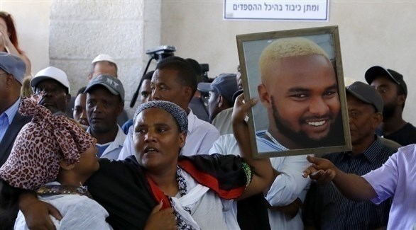 يهود أثيوبيين يرفعون صورة تيكا الذي قتل برصاص شرطي إسرائيلي (أ ف ب)