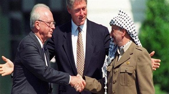 الزعيم الفلسطيني الراحل ياسر عرفات مصافحاً رئيس الوزراء الإسرائيلي الراحل اسحق رابين وبينها الرئيس الأمريكي الأسبق بيل كلينتون.(أرشيف)