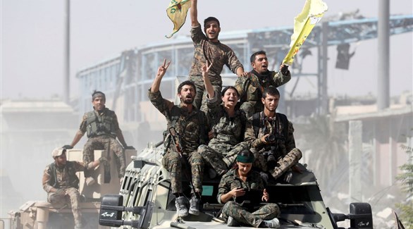 مقاتلون من قوات سوريا الديمقراطية وهم يحتفلون بهزيمة داعش في الرقة