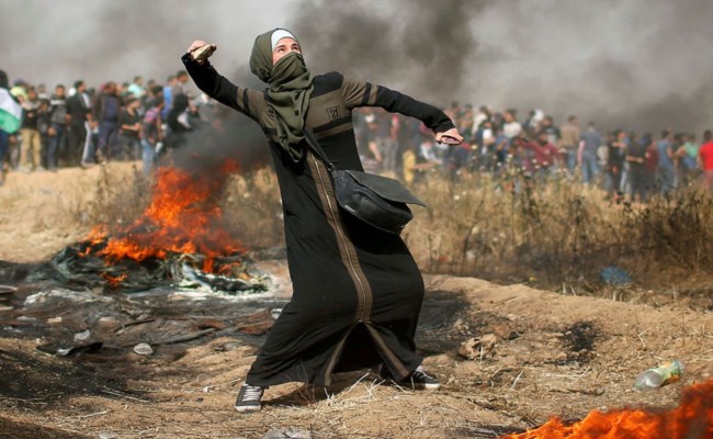 فلسطينية تقذف الحجارة باتجاه القوات الإسرائيلية خلال تظاهرة "حق العودة" في غزة