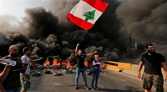 متظاهرون يقطعون طرقاً رئيسياً في لبنان بالإطارات المشتعلة (أ ف ب)
