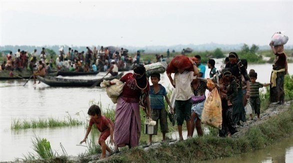 لاجئون من الروهينجا يمشون في طريق موحلة بعد عبور حدود بنغلاديش مع بورما (رويترز)