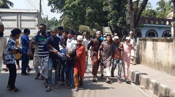 متظاهرون في بنغلادش ينقلون مصاباً في الاحتجاجات (أ ف ب)