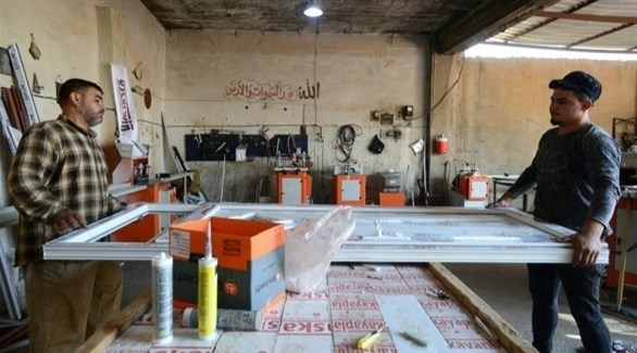 عراقيون في مصنع ألمنيوم بالموصل (أ ف ب)