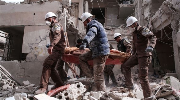 عاملون بالخوذ البيضاء ينقلون مصاباً في قصف على إحدى المدن السورية (أرشيف)