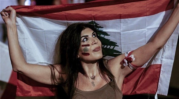 متظاهرة ترفع العلم اللبناني في وسط بيروت (اي بي ايه)