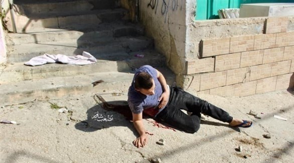 الشاب الفلسطيني عمر بدوي ينزف بعد إصابته برصاص قناصة الاحتلال والذي استشهد لاحقاً (تويتر) 