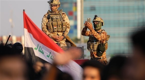 أمنيان عراقيان يلتقط سيلفي بين المتظاهرين (أ ف ب)