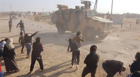 أكراد يرمون دبابة تركية بالحجارة في شمال شرق سوريا (أرشيف)