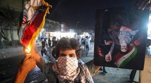 محتج عراقي يحرق العلم الإيراني في بغداد (أرشيف)