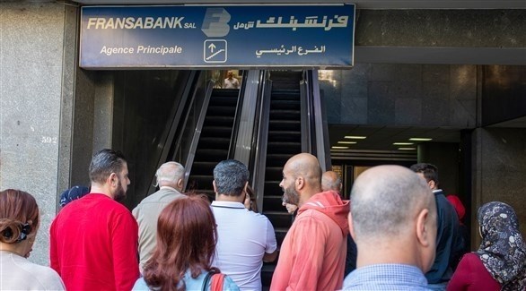 لبنانيون أمام أحد مداخل المصارف في بيروت (اي بي ايه)