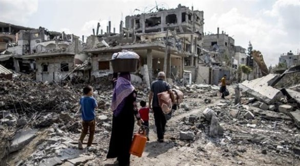 عائلة سورية وسط أنقاض مساكن هدمها القصف (أرشيف)
