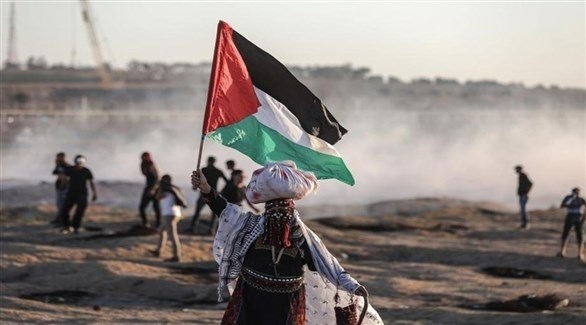 فلسطينية ترفع العلم في إحدى مسيرات العودة في غزة (أرشيف)