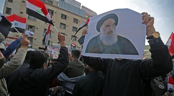 متظاهر يرفع صورة السيستاني في إحدى التجمعات في العراق (أرشيف / أ ف ب)