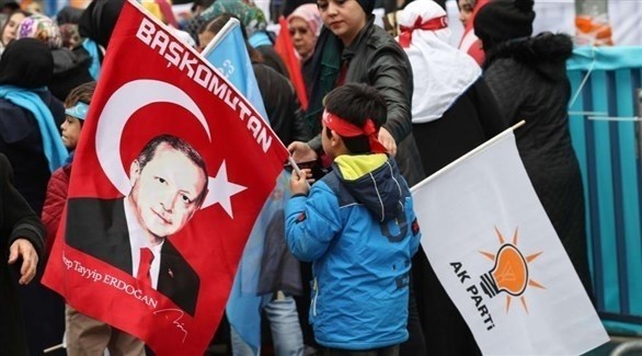 طفل يحمل علم حزب الرئيس التركي وصورة أردوغان (أرشيف)