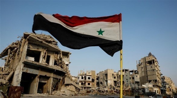 العلم السوري مرفرفاً بالقرب من الركام (أرشيف)