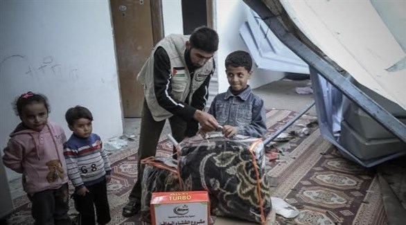 متطوع يوزع مساعدات اجتماعية على أطفال في غزة (أرشيف)