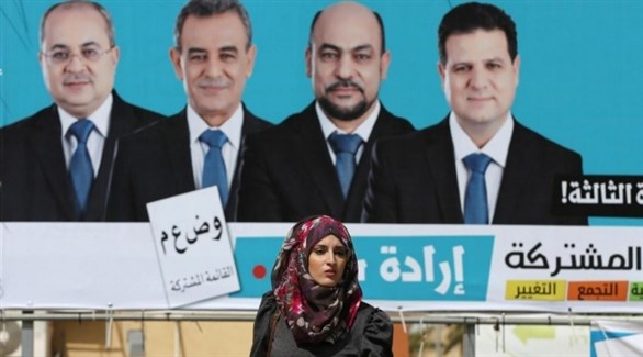 عربية إسرائيلية أمام معلقة انتخابية للقائمة العربية المشتركة (أرشيف)