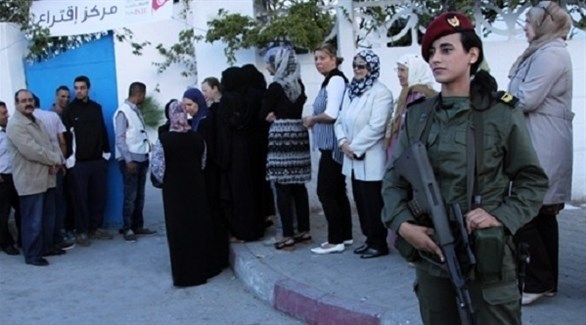 مجندة تونسية أمام مركز اقتراع (تويتر)