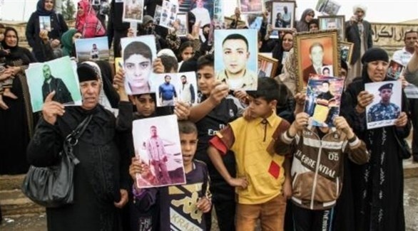 أمهات يحملن صور أبنائهن المفقودين في العراق.(أرشيف)