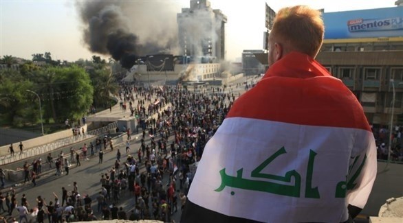 محتج عراقي يحمل علم بلاده (أرشيف)