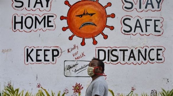 هندي أمام جدارية تدعو للوقاية من الفيروس (أرشيف)
