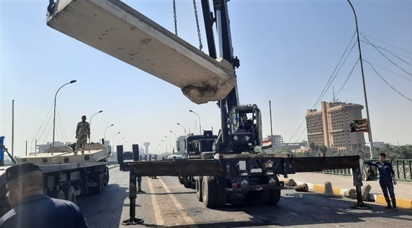 ألية ثقيلة ترفع الحواجز من جسر السنك في بغداد (تويتر)