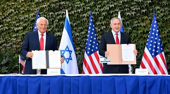 رئيس الوزراء الإسرائيلي بنيامين نتانياهو والسفير الأمريكي ديفيد فريدمان بعد توقيع الاتفاق (تويتر)