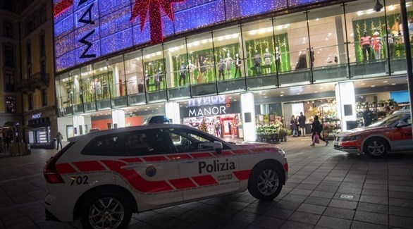 سيارة شرطة أمام المركز التجاري الذي شهد الهجوم في لوغانو السويسرية (تريبيون دو جنيف)